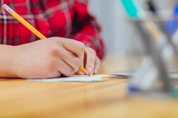 As mãos de uma jovem que trabalha no escritório. Durante este tempo segurando um lápis em suas mãos escreveu um plano de trabalho para o dia . — Fotografia de Stock