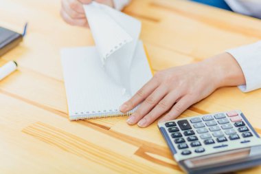 Masanın üzerinde elinde bir kağıt parçası yakalamak. Beyaz kağıdın. Notlar. Bir proje oluşturun. Levha. El yazmaları.