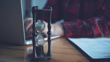 Bir bilgisayarda çalışan genç iş kadın. Casual giyim gömlek giymiş. Hourclock - bir laptop için çalışan eller bulanık bir arka plan üzerinde.