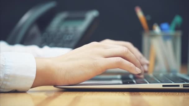 Mujer de negocios de mano. Una persona usando una computadora portátil, trabajando horas extras en su escritorio en la oficina . — Vídeos de Stock