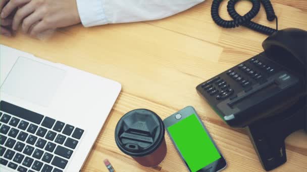 Jonge zakenvrouw werken voor een laptop. Op hetzelfde moment, klik op de knop om een oproep te doen. Plaats de handset en blijven werken. — Stockvideo