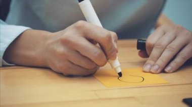 İşletme, pazarlama, planlama ve insan kavramı - bir kadının el bir lamba sarı bir kağıt üzerine çizim bir marker ile yakın çekim.