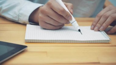 El iş kadını bir işaretleyici ev ofis masasında bir anlaşma için boyar. Satın alma ya da bir ev satış kavramı.