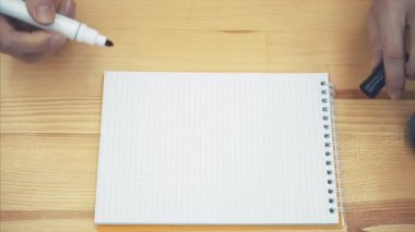 Genç kadın masanın üstüne eller. Kadının el siyah bir marker ile beyaz bir kağıda bir gülümseme boyar. Mutluluk, iyi bir ruh hali, kavramı-ebilmek var olmak kullanılmış için reklamları, kartpostallar.