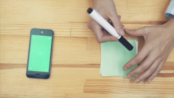 L'image carrelée d'un architecte avec un marqueur rouge et une ligne de dessin dessinant un croquis sur un bâtiment. Une vue de dessus des mains des femmes, dessinant différents signes sur du papier coloré pour le projet .