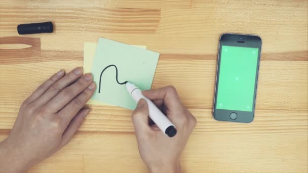 L'image carrelée d'un architecte avec un marqueur rouge et une ligne de dessin dessinant un croquis sur un bâtiment. Une vue de dessus des mains des femmes, dessinant différents signes sur du papier coloré pour le projet .