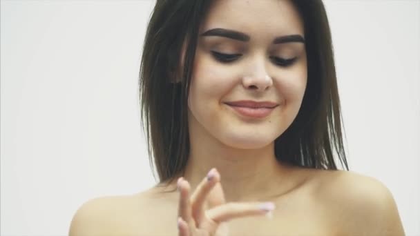 Primo piano felice giovane donna applicando crema al suo viso Skincare e cosmetici concetto. Cosmetici. Donna viso cura della pelle. trucco naturale, toccare il viso . — Video Stock