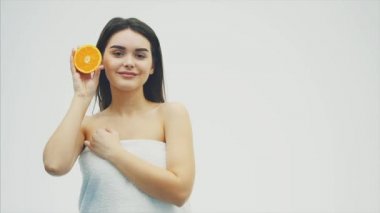 Güzel genç kız uzun saçlı deri ve mükemmel makyaj mükemmel. Turuncu meyve gözün arka plan üzerinde tutun. Beyaz arka plan.