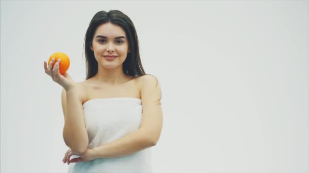 Retrato de mulher sorridente caucasiana atraente isolado no fundo branco com frutas laranja. Beleza, cuidado, pele, tratamento, saúde, spa, cosméticos e conceitos publicitários . — Vídeo de Stock