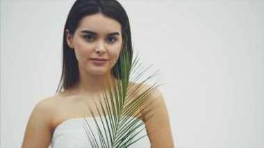 Doğal makyaj, uzun kirpik ve ferns yaprak yeşil genç güzel gülümseyen modeli. Spa, Cilt Bakımı ve sağlık. Güzellik ve cilt bakım kavramları.