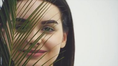 Doğal makyaj, uzun kirpik ve ferns yaprak yeşil genç güzel gülümseyen modeli. Spa, Cilt Bakımı ve sağlık. Güzellik ve cilt bakım kavramları.