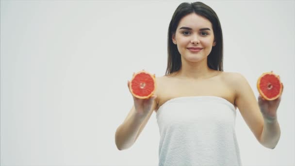 La bellezza di una donna è da pompelmo agli agrumi arancione con una pelle sana del corpo. Vitamina fresca attraente. Studio girato . — Video Stock