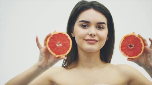 The beauty of a woman is from orange citrus grapefruit with healthy skin of the body. Attractive fresh vitamin. Studio shot. — Stock Video