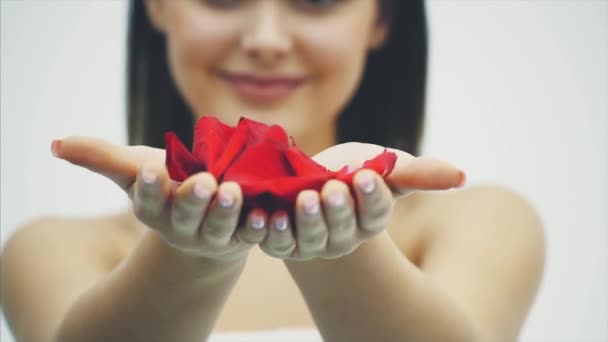 Élégance et tendresse. Belle jeune femme brune cheveux souffle les pétales de la terre . — Video