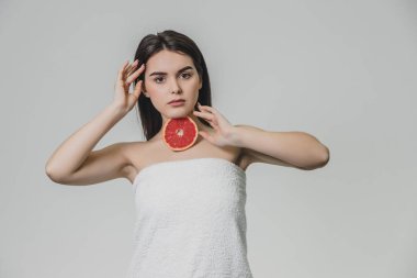 Mutlu bir genç kız meyve ile poz veriyor. Bu zamana kadar o boynundaki greyfurt bir parça koy. Baş boyun için diğer bir yandan dokunmadan.