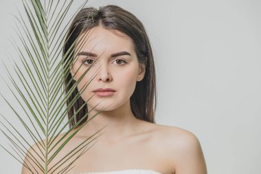 Beyaz bir arka plan üzerinde genç ve güzel bir kız var. Çekici bir genç kadın eğreltiotu ile poz close-up. Güzel uzun saçlı.