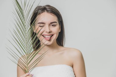 Beyaz bir arka plan üzerinde genç ve güzel bir kız var. Çekici bir genç kadın eğreltiotu ile poz close-up. Güzel uzun saçlı.