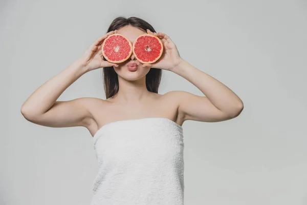 Joven chica sexy posando con rodajas de pomelo rojo en su cara cubriendo sus ojos . — Foto de Stock