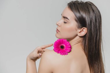 Genç güzel kadın ile lotus çiçeği izole Spa'da rahatlatıcı. Onu yüzüne yerleştirerek bu el sırasında kaldırdı.