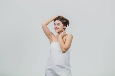 Beyaz bir arka plan üzerinde esmer kadın mutlu, eğlenceli. Kameraya kadar güzel siyah saçları ile oynarken arıyorum. Onun saç aldı ve onun elini yana doğru seyir tutmak.