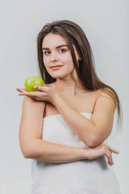 Güzel genç kız ile bir doğal doğal makyaj ve onun elinde apple ile mükemmel cilt. Güzellik yüz Studio beyaz zemin üzerine resim.