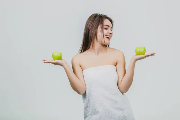 Divertida mujer riendo sosteniendo dos manzanas verdes en sus ojos. Fondo blanco de un concepto de alimentación saludable. Dieta — Foto de Stock