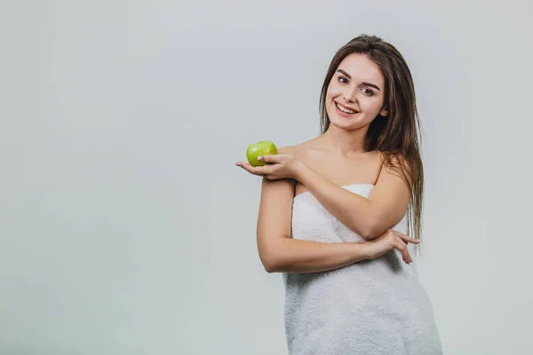 Hermosa joven con un maquillaje natural natural y una piel perfecta con manzana en la mano. Cara de belleza Imagen tomada en el estudio sobre fondo blanco . — Foto de Stock