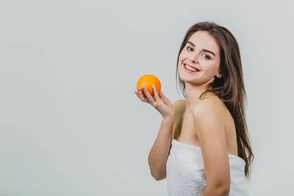 여자의 초상화는 귀여운 젊은 매력적인 반-그녀의 손과 흰색 배경 위에 절연 카메라 보고에 오렌지는 오렌지를 들고. — 스톡 사진