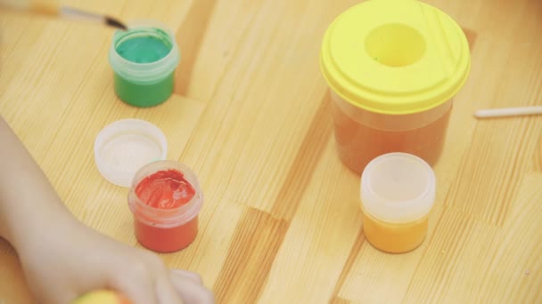 Flicka, grundar av hantverk och måleri, sätter en naken färg-borste — Stockvideo