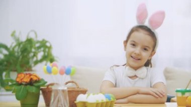 Küçük şirin ve sevimli kız içtenlikle gülümsüyor. Kız üzerinden pompalama, tavşan kulakları kafasına takıyor. Kavram Paskalya tatili.