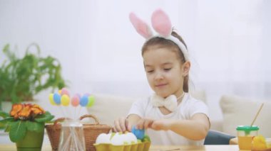 Küçük şirin ve sevimli kız gülümseyerek ve iskambil ile renkli tavuk yumurta onun elinde. Kavram Paskalya tatili.
