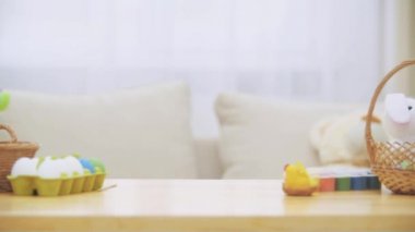 Sevimli küçük kız tavşan kulakları ile Paskalya süsleri tam masanın altına saklanıyor. Küçük sevimli beyaz kız yüzleri yapıyor. Reklam odam.