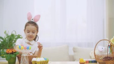Litle oynak kız, tavşan kulakları kafasında giyen bir Paskalya yumurtası seçmektir. Aniden, biri onu fark ettim. O korkmuş ve aşağı sakladım.