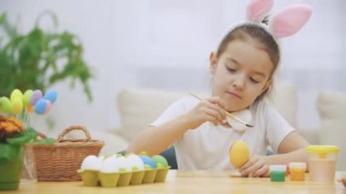 Küçük oynak kız, tavşan kulakları kafasında giymiş seçerek bir kırmızı bir yumurta boyamak için renk ve sakince bir Paskalya yumurta boya. Girol bir kalp üzerine boyalı vardır, o zaman bir jest sevgi gösterir.