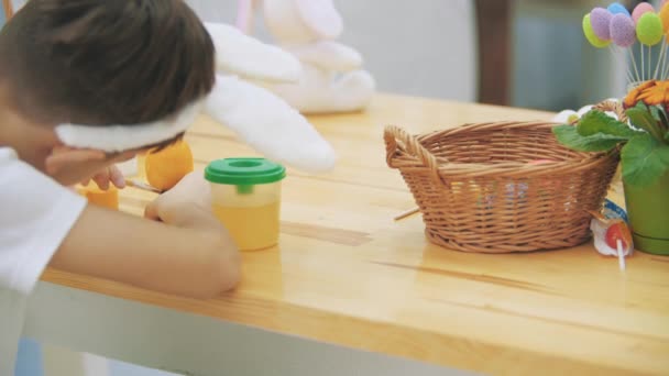 Kíváncsi fiú a befejező, hogy colourize egy húsvét tojás, sárga színnel. — Stock videók