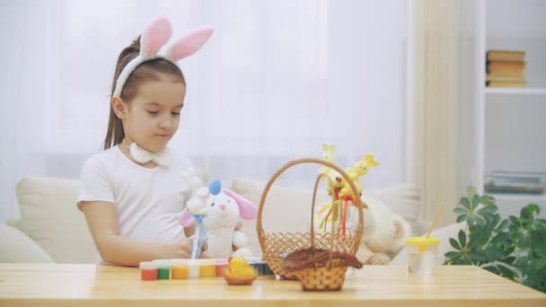 Pequeña chica linda y adorable está sonriendo y jugando con conejitos de Pascua en sus manos. Concepto vacaciones de Pascua . — Vídeos de Stock