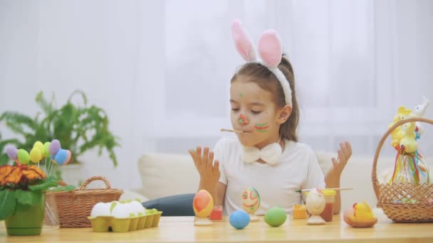 Miła, Ładna dziewczyna jest dobra zabawa malarstwo. Urocza dziewczyna jest kolorowanie i jej ręce, z pomocą pędzla w jej ustach. Dziewczyna z pięknych miejsc na nią twarz i jest delikatnie uśmiechając się z "Kocie wąsy" — Wideo stockowe