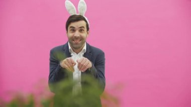Genç çift, pembe arka plan güzel. Bu süre boyunca, onlar ayaktakımı kulaklarında giyindin. Birbirine bakarak, konuşan ve gülen, tavşanlar gibi davranır.