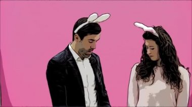Genç çift, pembe arka plan güzel. Bu süre boyunca, onlar ayaktakımı kulaklarında giyindin. Birbirine bakarak, ağız ve diş hareketleri üreyen tavşanlar gibi davranır. Paskalya.
