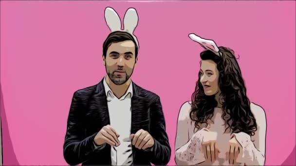 Mooie, jonge inschrijving creatieve paar staande op een roze achtergrond. Op hetzelfde moment toont gek de bewegingen van konijnen. Gekleed in de oren van een haak. Pasen. Ontwerp-resoluties. — Stockvideo