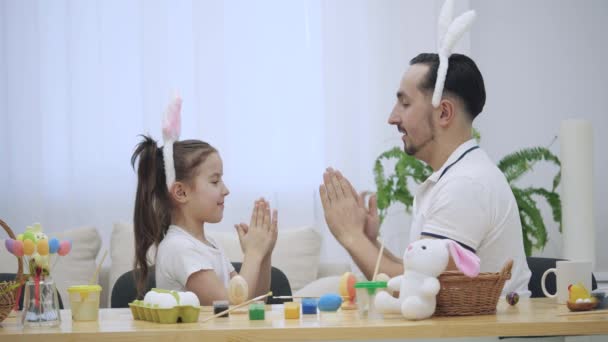 Padre está enseñando a su hija a jugar un juego. Están jugando con sus manos juego agradable e interesante, infantil . — Vídeo de stock