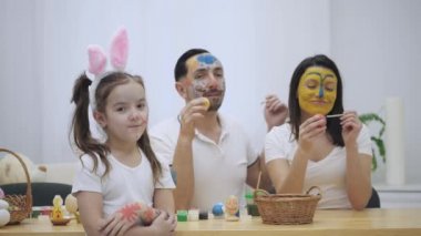 Hoş bir çift birbirine Paskalya boya fırçası yardımıyla renklendirme. Onların kızı diyor ki: 
