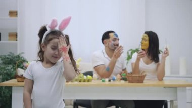 Hoş bir çift birbirine Paskalya boya-fırça, bulanık arka planda bir yardımı ile renklendirme. Onların kızı diyor ki: 