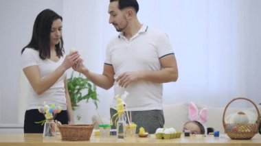 Küçük kardeşler aileleri gelirken bir masanın altına, Paskalya süslemeleri, tam gizleme ve bakıyorsun, masanın üstünde yer alan öğeler, dokunaklı. Ebeveynler için arıyorlar