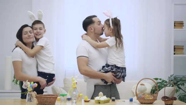 Famiglia felice e allegra: madre, padre e due figli sorridono ampiamente e condividono le loro emozioni positive sullo sfondo bianco. I genitori tengono i figli per mano. Papà è... — Video Stock