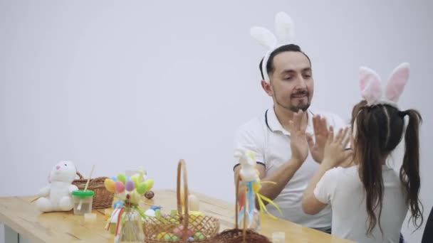 Papà sta facendo un gioco con sua figlia. Stanno giocando con le loro mani bello e interessante, gioco infantile. Padre e sua figlia si stanno abbracciando fermamente alla fine. Fronte offuscata . — Video Stock