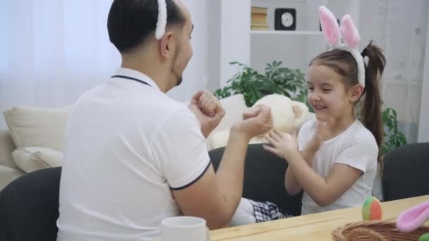 O pai alegre está a brincar com a filha. Eles estão jogando com as mãos agradável e interessante, jogo infantil . — Vídeo de Stock