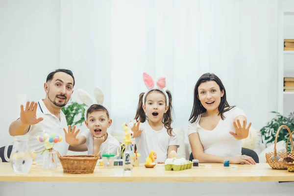 Emocjonalne Wielkanoc rodzina siedzi przy stole, rozszerzanie ich ręce do przodu, wyświetlone jest znak stop. Otwórz mouthes, ekspresję na ich twarzach. — Zdjęcie stockowe