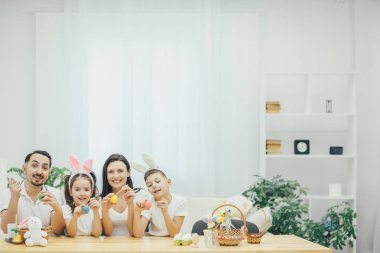 Aile oturma birlikte tablo, kardeşi ve kız kardeşi tavşan kulakları esin kaynağı oldu. Herkes farklı Paskalya yumurtaları farklı renklerle boyama.