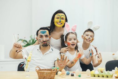 Yaratıcı aile, tavşan kulakları çocuklarda. Renkli yüz herkesle. Onlar son derece mutlu olan ve gülümseyen ve komik poz kameraya gösteren.